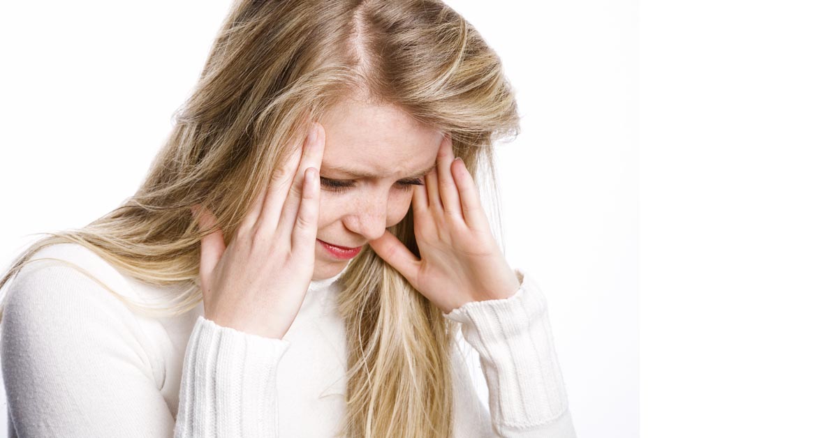 woman holding her temples of head